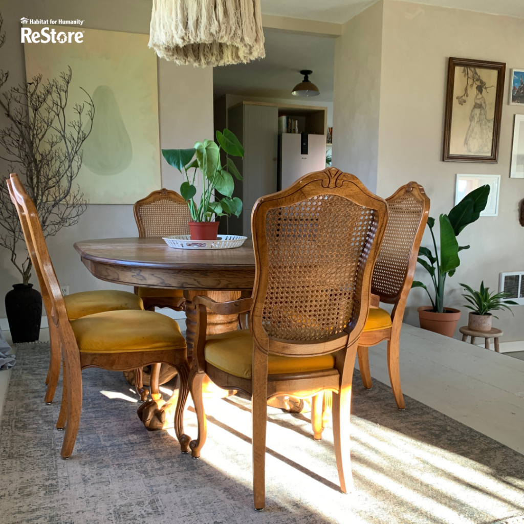 A room with a dining table attached with six brown chairs with yellow padding.