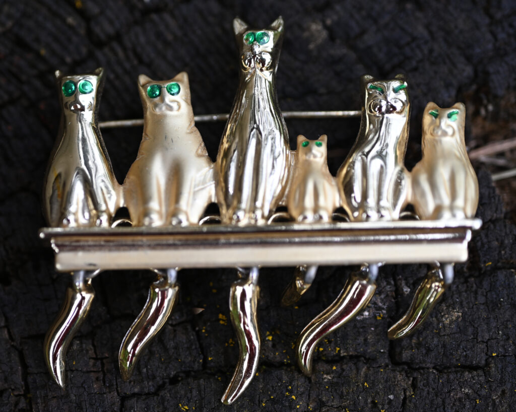 Gresham ReStore jewelry sale image of six silver cats on a shelf pin
