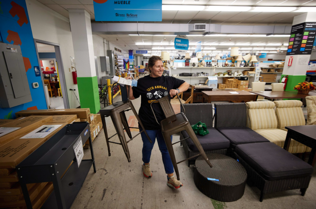 Volunteer putting stools in furniture area of Portland ReStore